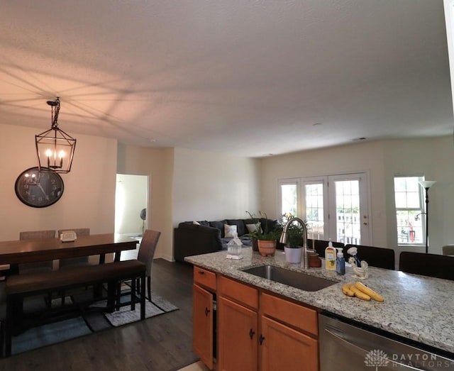 3224 Grand Falls Blvd, Maineville, OH 45039 - kitchen featuring stainless steel dishwasher, open floor plan, dark wood-style floors, light stone countertops, and decorative light fixtures