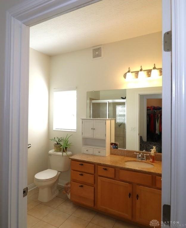 3224 Grand Falls Blvd, Maineville, OH 45039 - bathroom featuring tile patterned floors, vanity, a shower stall, and a walk in closet