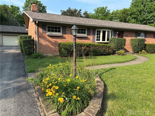 215 W Martindale Rd, Englewood, OH 45322 - single story home with brick siding, a chimney, a front yard, asphalt driveway, and a shingled roof