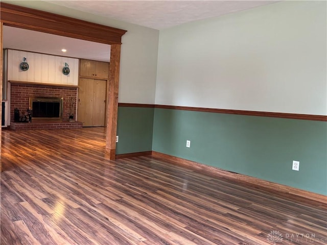 215 W Martindale Rd, Englewood, OH 45322 - unfurnished living room featuring wood finished floors and a brick fireplace