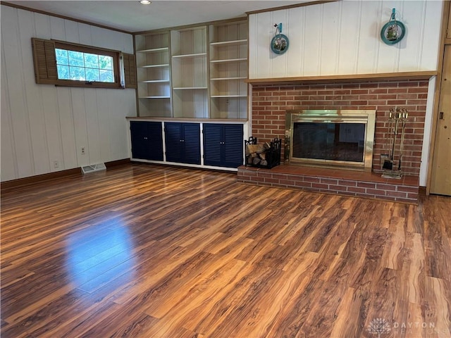 215 W Martindale Rd, Englewood, OH 45322 - unfurnished living room featuring wood finished floors, a brick fireplace, crown molding, and wooden walls