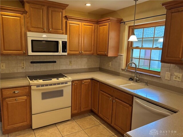 215 W Martindale Rd, Englewood, OH 45322 - kitchen with white appliances, hanging light fixtures, brown cabinets, light tile patterned floors, and light countertops