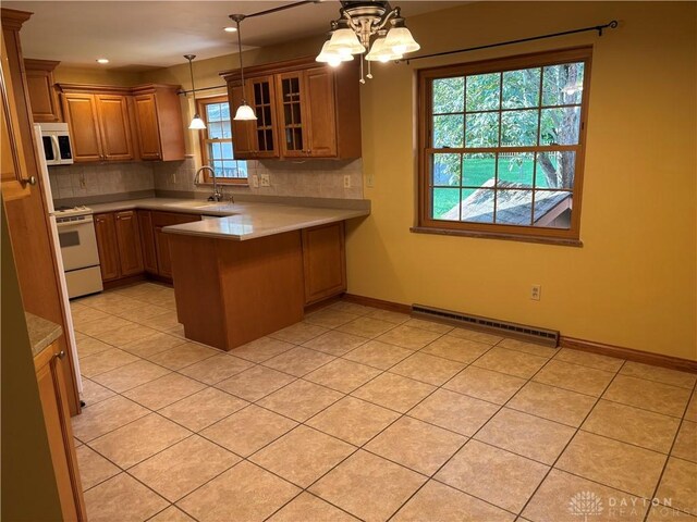 215 W Martindale Rd, Englewood, OH 45322 - kitchen featuring white appliances, a peninsula, decorative backsplash, light countertops, and recessed lighting