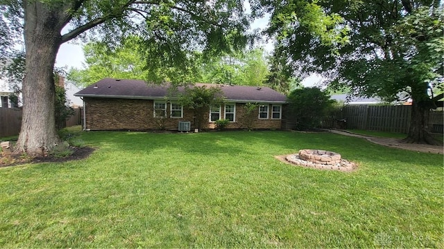 5468 Split Rock Dr, Dayton, OH 45424 - rear view of property with a fenced backyard, an outdoor fire pit, and brick siding