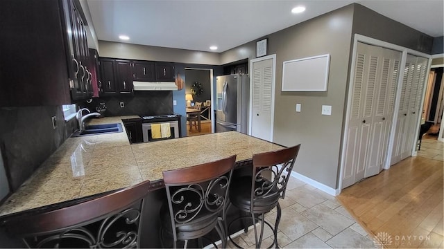 5468 Split Rock Dr, Dayton, OH 45424 - kitchen with stainless steel appliances, under cabinet range hood, a peninsula, tasteful backsplash, and tile countertops