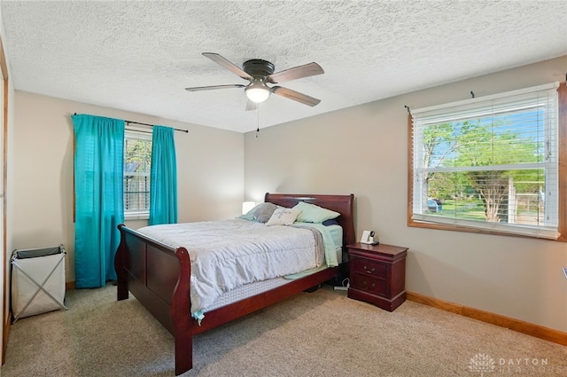 2946 Rockledge Trl, Beavercreek, OH 45430 - bedroom with multiple windows, carpet flooring, a ceiling fan, and a textured ceiling