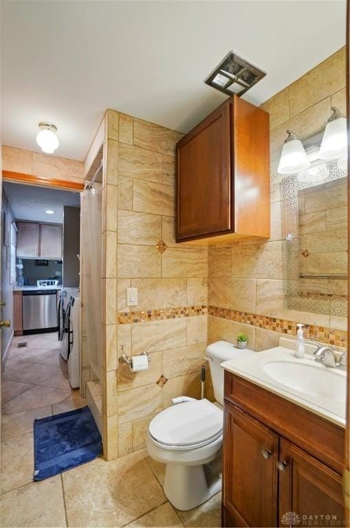 2946 Rockledge Trl, Beavercreek, OH 45430 - bathroom with tile walls, separate washer and dryer, a shower stall, vanity, and tile patterned flooring