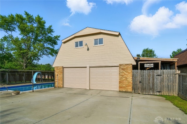 2946 Rockledge Trl, Beavercreek, OH 45430 - view of side of home with brick siding, a garage, concrete driveway, and a gambrel roof