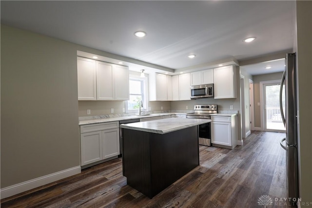 506 Linden Ave, Dayton, OH 45403 - kitchen with stainless steel appliances, dark wood-style flooring, white cabinets, recessed lighting, and a kitchen island