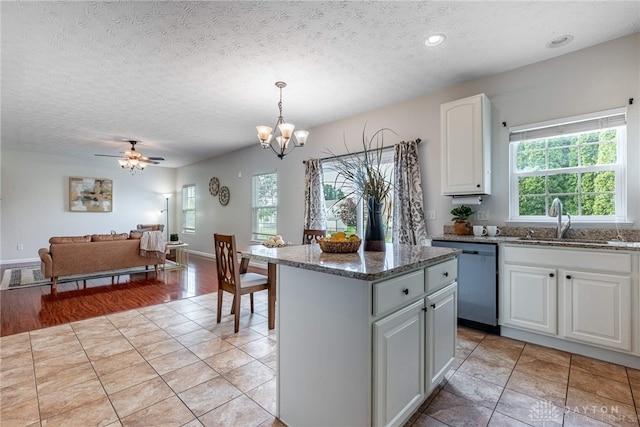 1928 Spring Ridge Dr, Xenia, OH 45385 - kitchen with dishwasher, a kitchen island, a textured ceiling, white cabinets, and dark stone counters