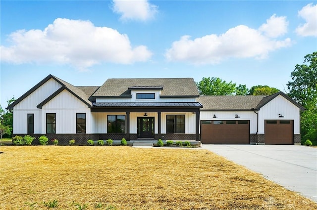 8559 Wandering Brook Way, Waynesville, OH 45068 - modern farmhouse style home featuring a standing seam roof, a front lawn, covered porch, board and batten siding, and a shingled roof