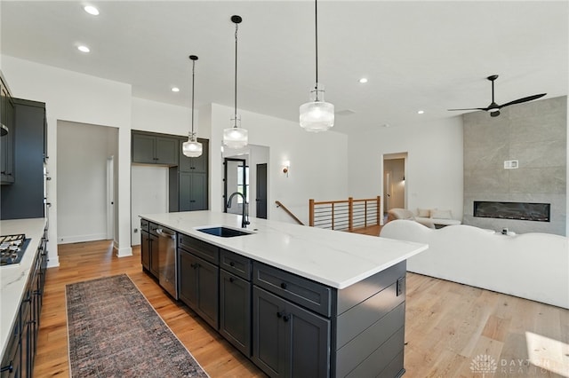 8559 Wandering Brook Way, Waynesville, OH 45068 - kitchen with appliances with stainless steel finishes, light wood-type flooring, a kitchen island with sink, ceiling fan, and recessed lighting