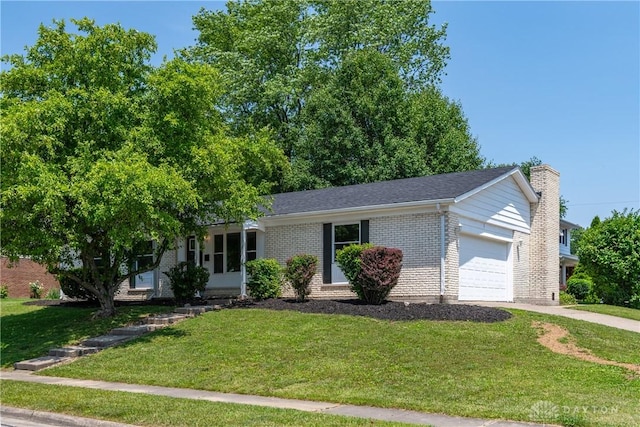 390 Washington Ave, Wilmington, OH 45177 - view of front of house featuring an attached garage, brick siding, a front lawn, a chimney, and driveway
