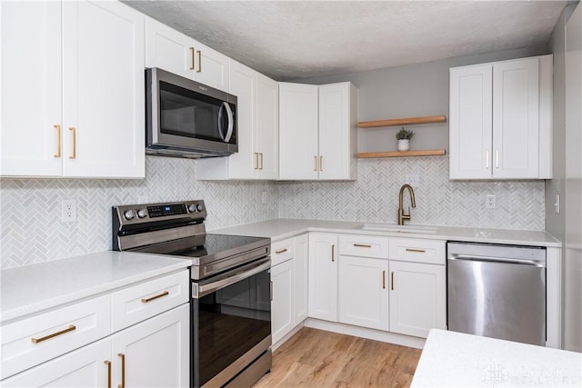 390 Washington Ave, Wilmington, OH 45177 - kitchen featuring stainless steel appliances, light countertops, open shelves, white cabinets, and a textured ceiling