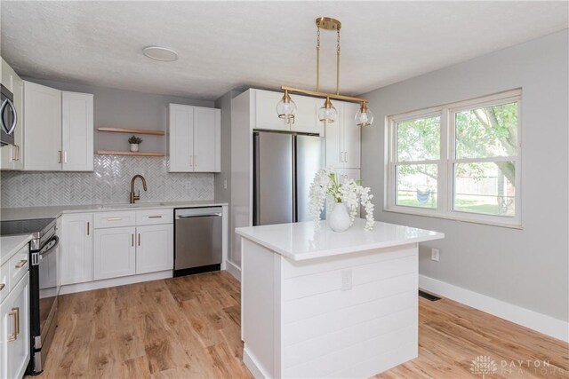 390 Washington Ave, Wilmington, OH 45177 - kitchen with appliances with stainless steel finishes, open shelves, decorative backsplash, and light wood-type flooring