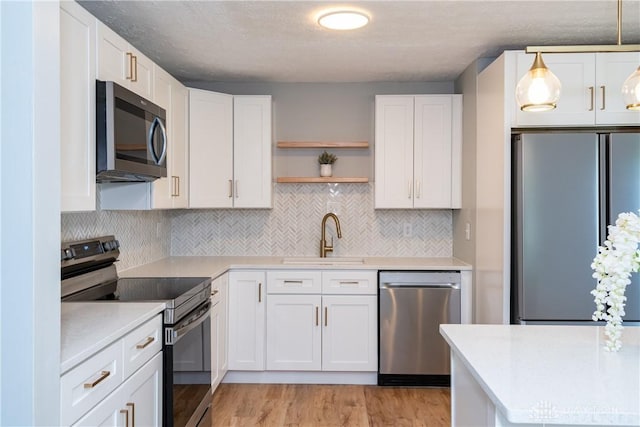 390 Washington Ave, Wilmington, OH 45177 - kitchen featuring appliances with stainless steel finishes, open shelves, white cabinets, and tasteful backsplash