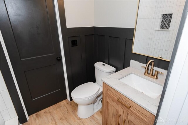 390 Washington Ave, Wilmington, OH 45177 - half bath featuring vanity, wood finished floors, a decorative wall, and wainscoting