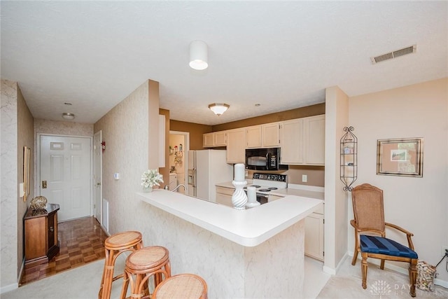 7636 Shawnee Ln Unit 206, West Chester, OH 45069 - kitchen featuring white appliances, light countertops, a breakfast bar, and a peninsula