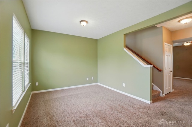 1956 Daffodil Dr, Xenia, OH 45385 - carpeted empty room featuring baseboards and stairway