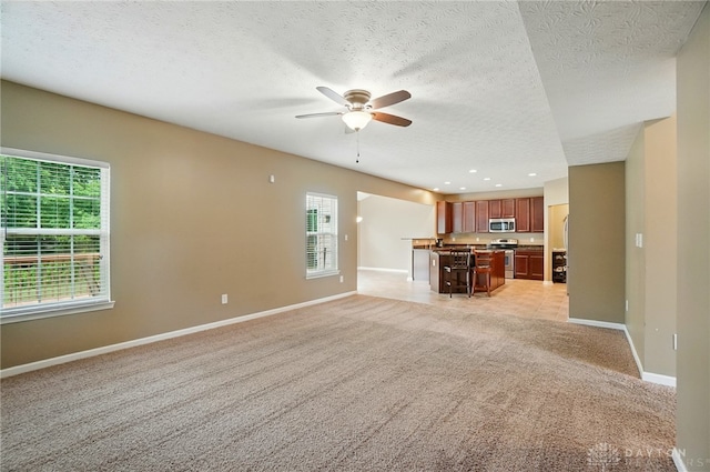 1956 Daffodil Dr, Xenia, OH 45385 - unfurnished living room with ceiling fan, light carpet, a textured ceiling, and recessed lighting