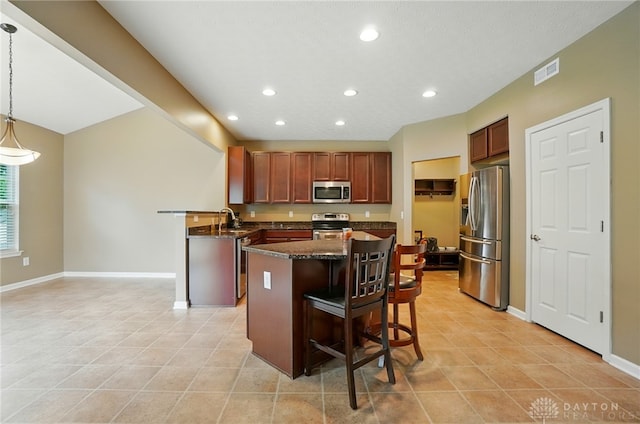 1956 Daffodil Dr, Xenia, OH 45385 - kitchen featuring stainless steel appliances, recessed lighting, a kitchen bar, a center island, and light tile patterned floors