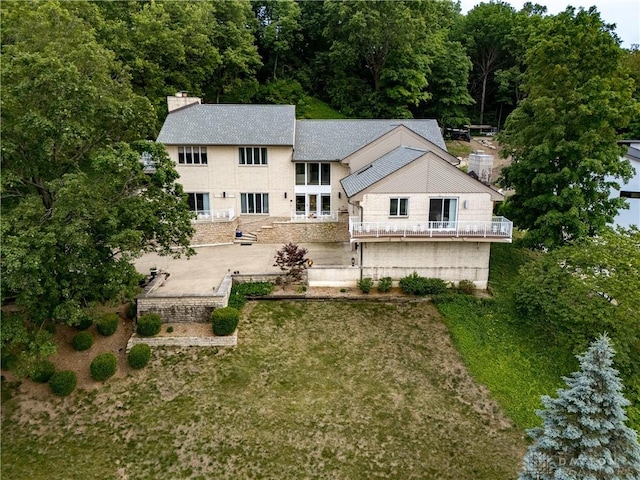 1952 Tait Circle Rd, Dayton, OH 45429 - rear view of house featuring a chimney, a balcony, a shingled roof, and a patio