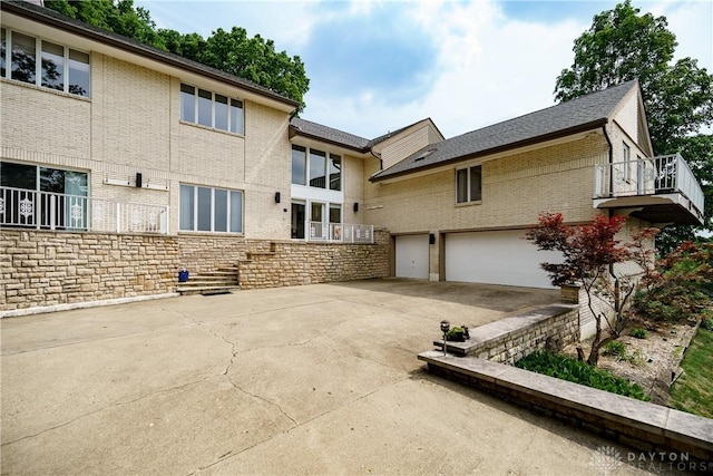 1952 Tait Circle Rd, Dayton, OH 45429 - rear view of property with concrete driveway, a garage, brick siding, and stone siding