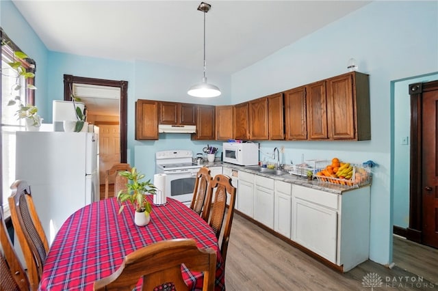 57 S Torrence St, Dayton, OH 45403 - kitchen with white appliances, under cabinet range hood, light wood finished floors, pendant lighting, and brown cabinetry