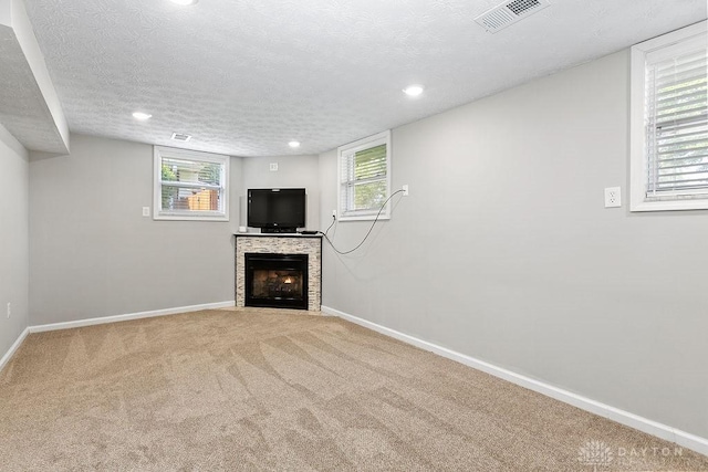 6814 Rushleigh Rd, Englewood, OH 45322 - below grade area with a fireplace with flush hearth, carpet floors, recessed lighting, a textured ceiling, and plenty of natural light