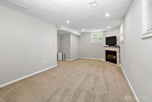 6814 Rushleigh Rd, Englewood, OH 45322 - unfurnished living room featuring light colored carpet, a warm lit fireplace, recessed lighting, and a textured ceiling