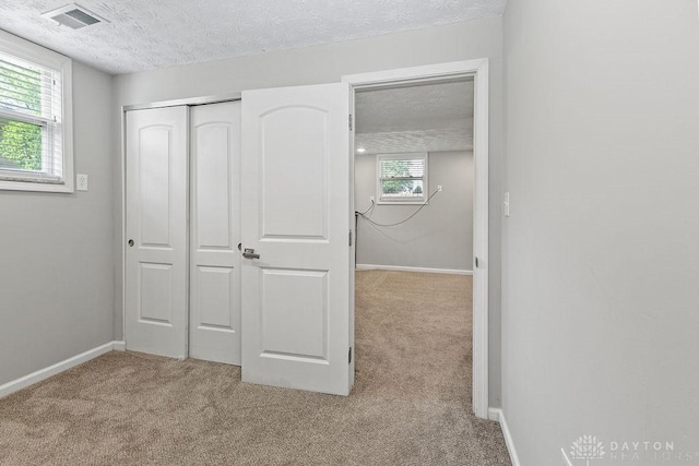6814 Rushleigh Rd, Englewood, OH 45322 - unfurnished bedroom featuring carpet flooring, a textured ceiling, and a closet