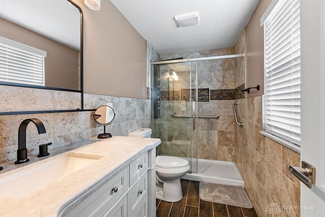 6814 Rushleigh Rd, Englewood, OH 45322 - bathroom with tile walls, vanity, a stall shower, and wood finished floors