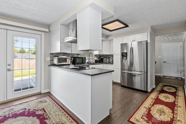 6814 Rushleigh Rd, Englewood, OH 45322 - kitchen featuring stainless steel fridge with ice dispenser, a textured ceiling, a peninsula, wall chimney range hood, and white cabinetry