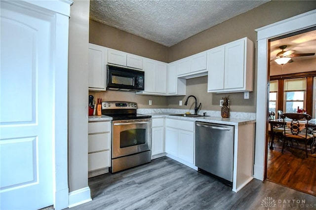 2457 Wilbraham Rd, Middletown, OH 45042 - kitchen featuring stainless steel appliances, wood finished floors, white cabinetry, and a textured ceiling