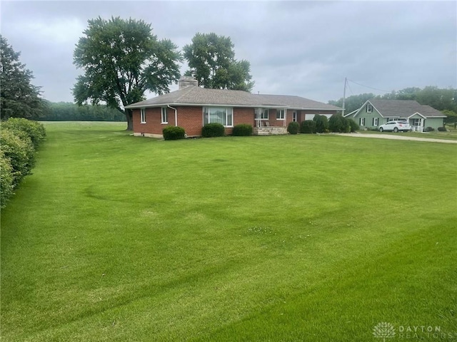 311 Swailes Rd, Troy, OH 45373 - view of front of house with a chimney, a front lawn, and brick siding