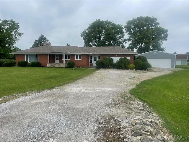 311 Swailes Rd, Troy, OH 45373 - ranch-style home with an outdoor structure, a garage, a front lawn, and brick siding