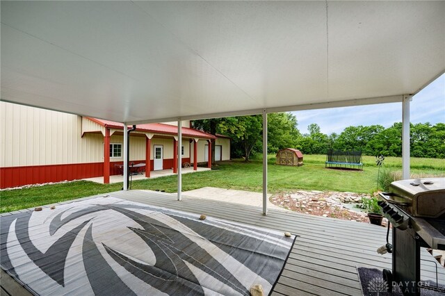 8282 Hile Ln, Germantown, OH 45327 - wooden terrace featuring a trampoline, a grill, a yard, and a storage unit