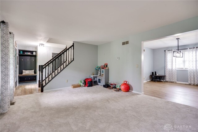 8282 Hile Ln, Germantown, OH 45327 - unfurnished living room with carpet flooring, stairs, and wood finished floors