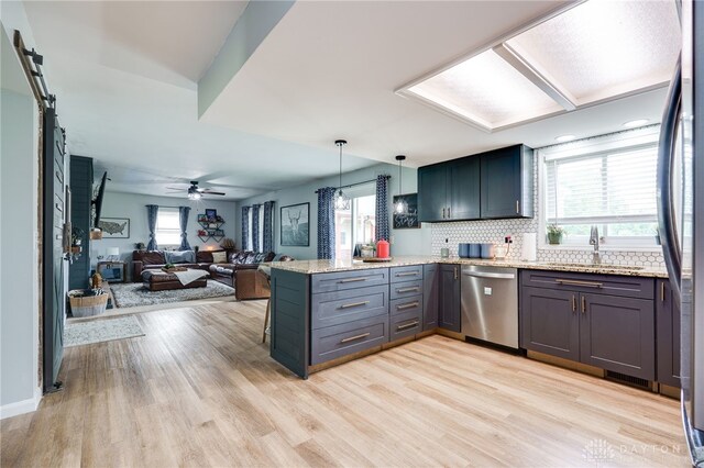 8282 Hile Ln, Germantown, OH 45327 - kitchen with appliances with stainless steel finishes, a peninsula, plenty of natural light, and light wood-type flooring