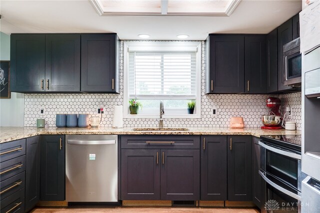 8282 Hile Ln, Germantown, OH 45327 - kitchen with appliances with stainless steel finishes, tasteful backsplash, and light stone counters