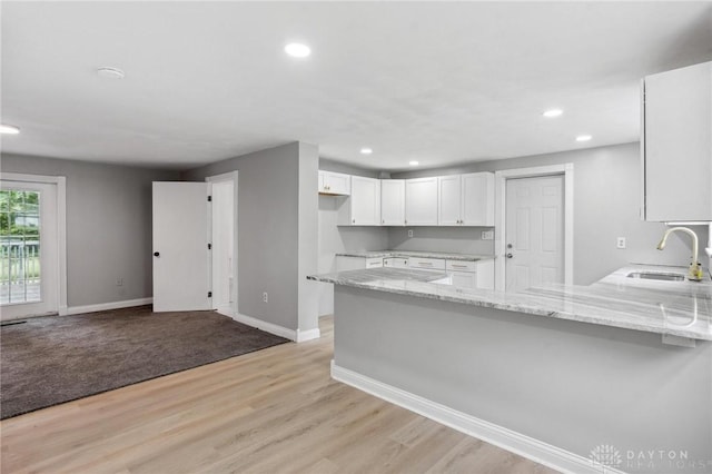 1189 Spinning Rd, Dayton, OH 45432 - kitchen featuring a peninsula, light stone countertops, white cabinetry, recessed lighting, and light wood-style flooring