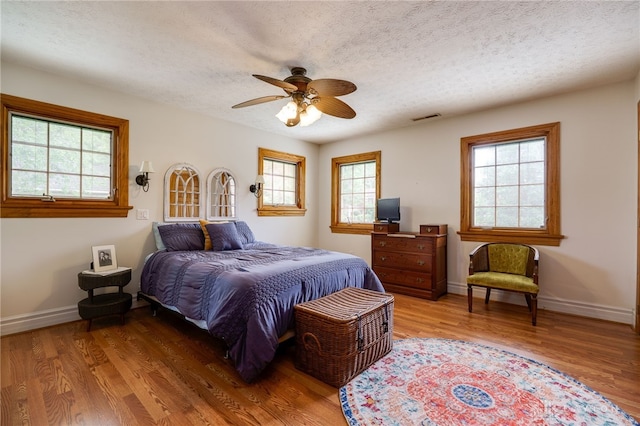 164 Winding Way, Kettering, OH 45429 - bedroom with multiple windows, wood finished floors, a textured ceiling, and a ceiling fan
