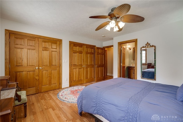 164 Winding Way, Kettering, OH 45429 - bedroom featuring light wood-type flooring, multiple closets, ceiling fan, and ensuite bathroom