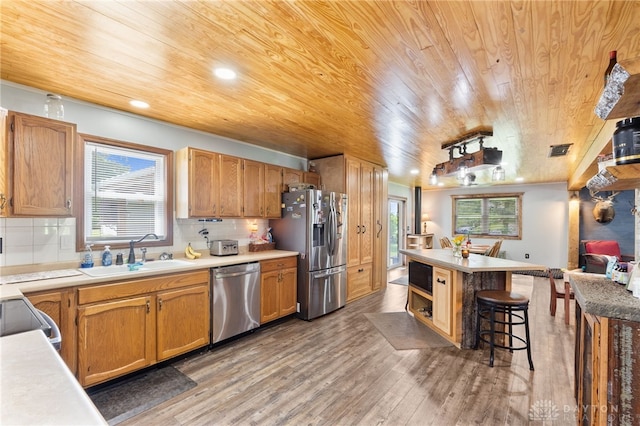 3075 Addison New Carlisle Rd, New Carlisle, OH 45344 - kitchen with stainless steel appliances, wood ceiling, light wood finished floors, a breakfast bar, and light countertops