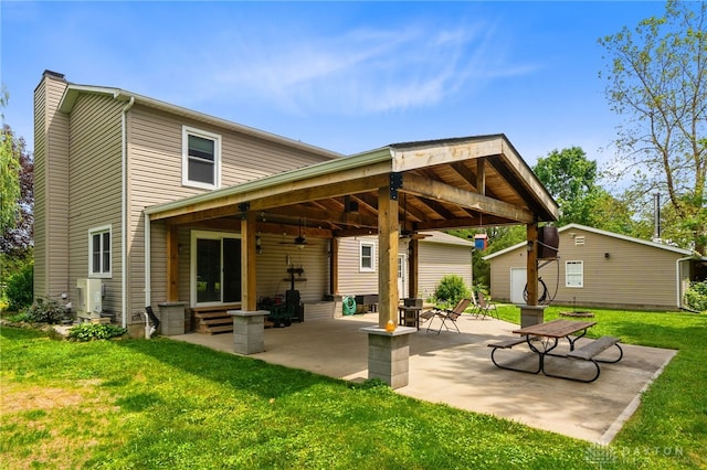 3075 Addison New Carlisle Rd, New Carlisle, OH 45344 - rear view of house with a ceiling fan, a lawn, a patio area, entry steps, and a chimney