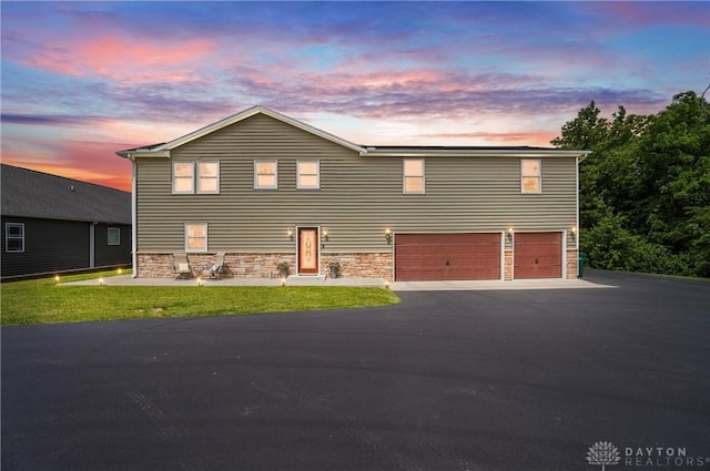 855 Quarry Rd, Silver Creek Twp, OH 45335 - view of front facade featuring an attached garage, stone siding, driveway, and a front yard