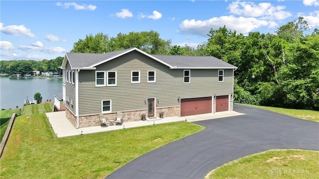 855 Quarry Rd, Silver Creek Twp, OH 45335 - view of front of home with a garage, driveway, stone siding, and a front lawn