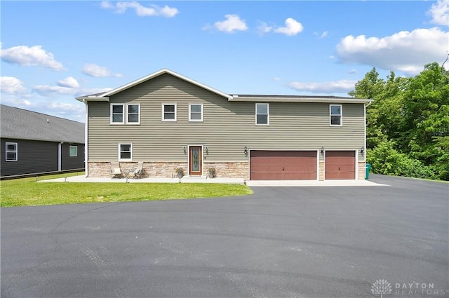 855 Quarry Rd, Silver Creek Twp, OH 45335 - view of front of house with a garage, stone siding, a front lawn, and asphalt driveway