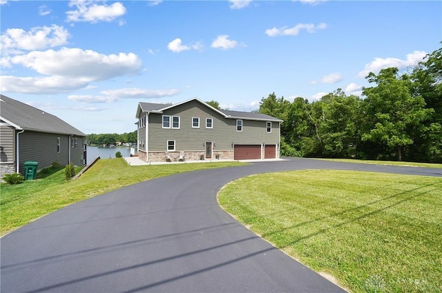 855 Quarry Rd, Silver Creek Twp, OH 45335 - view of front of house with a garage, asphalt driveway, a front lawn, and a water view