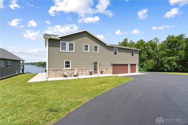 855 Quarry Rd, Silver Creek Twp, OH 45335 - view of front of property with a garage, stone siding, asphalt driveway, and a front yard
